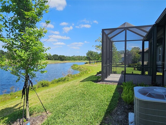 3776 Maxwell Park Dr, Sun City Center, FL 33573 - view of grassy yard with central AC, a water view, and glass enclosure