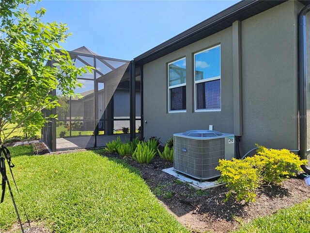 3776 Maxwell Park Dr, Sun City Center, FL 33573 - view of green lawn featuring cooling unit, a lanai, and a patio
