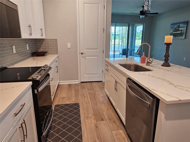 3776 Maxwell Park Dr, Sun City Center, FL 33573 - kitchen with black range with electric stovetop, dishwasher, a sink, light wood-style flooring, and tasteful backsplash