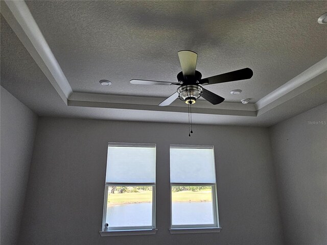 3776 Maxwell Park Dr, Sun City Center, FL 33573 - detailed view of a textured ceiling, a ceiling fan, and a raised ceiling