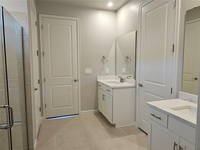 3776 Maxwell Park Dr, Sun City Center, FL 33573 - bathroom featuring two vanities, a shower stall, baseboards, and tile patterned floors