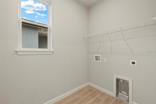 3776 Maxwell Park Dr, Sun City Center, FL 33573 - laundry area featuring hookup for an electric dryer, hookup for a washing machine, baseboards, and light wood-type flooring