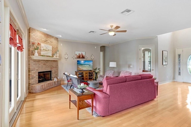 2502 Fritzke Rd, Dover, FL 33527 - living room featuring light wood-type flooring, ceiling fan, a brick fireplace, baseboards, and crown molding