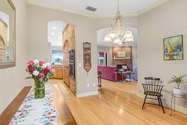 2502 Fritzke Rd, Dover, FL 33527 - corridor featuring light wood-style floors, arched walkways, ornamental molding, baseboards, and a chandelier