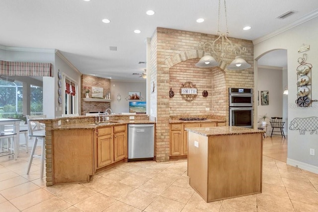 2502 Fritzke Rd, Dover, FL 33527 - kitchen featuring appliances with stainless steel finishes, a sink, crown molding, a center island, and light tile patterned floors