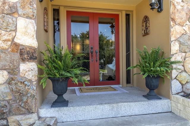 2287 Demaret Dr, Dunedin, FL 34698 - view of exterior entry featuring french doors and stone siding