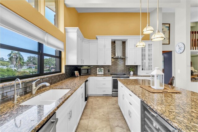 2287 Demaret Dr, Dunedin, FL 34698 - kitchen featuring stainless steel appliances, wall chimney exhaust hood, a sink, beverage cooler, and decorative backsplash