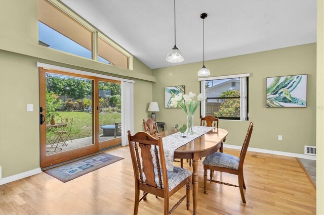 2287 Demaret Dr, Dunedin, FL 34698 - dining space with plenty of natural light, light wood-style flooring, baseboards, and high vaulted ceiling