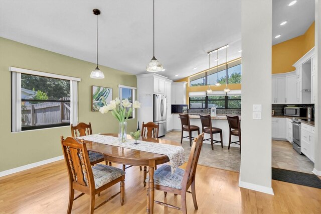 2287 Demaret Dr, Dunedin, FL 34698 - dining room with light wood-style flooring, lofted ceiling, baseboards, and recessed lighting
