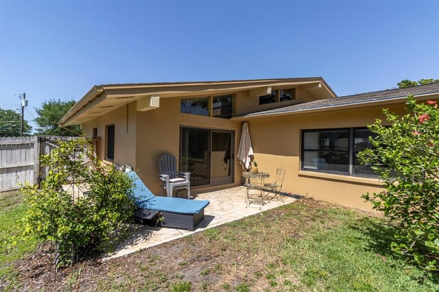 2287 Demaret Dr, Dunedin, FL 34698 - back of house featuring stucco siding and a patio area
