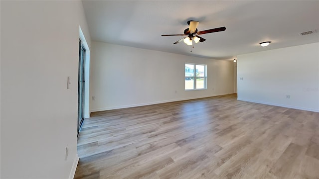 empty room featuring a ceiling fan, baseboards, and light wood-style flooring