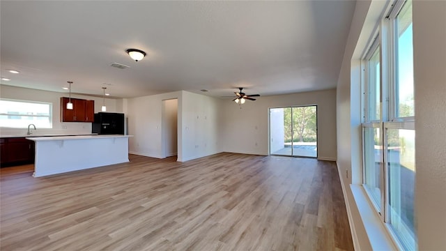 unfurnished living room with a sink, light wood finished floors, baseboards, a ceiling fan, and recessed lighting