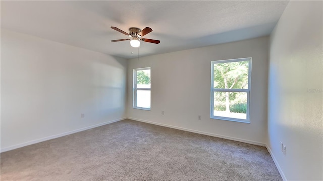 spare room featuring carpet floors, ceiling fan, and baseboards