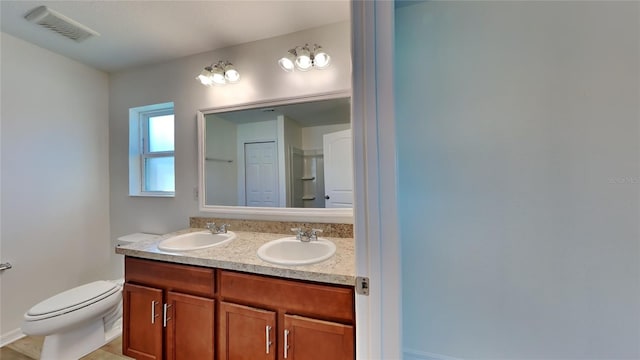 bathroom featuring toilet and double vanity