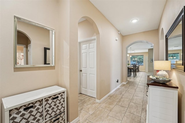 9917 Prevatt St, Gibsonton, FL 33534 - corridor featuring arched walkways, light tile patterned flooring, and baseboards