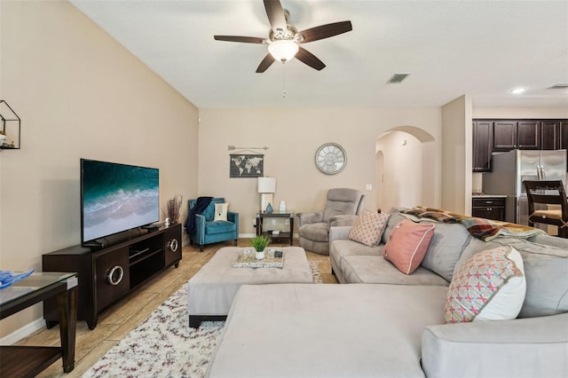 9917 Prevatt St, Gibsonton, FL 33534 - living room featuring arched walkways, a ceiling fan, light tile patterned flooring, and baseboards