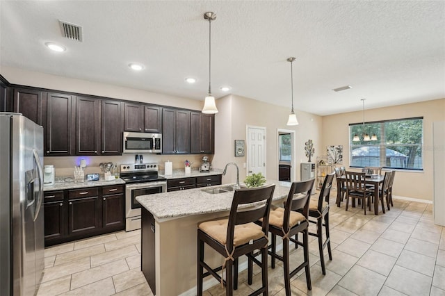 9917 Prevatt St, Gibsonton, FL 33534 - kitchen with appliances with stainless steel finishes, a sink, light tile patterned flooring, dark brown cabinets, and recessed lighting