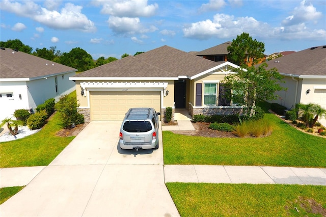 13327 Waterleaf Garden Cir, Riverview, FL 33579 - view of front of property featuring stone siding, an attached garage, concrete driveway, and a front lawn