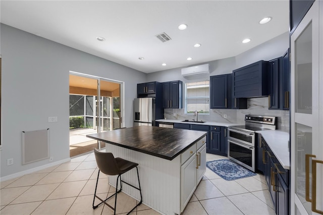 17809 Sandpine Trace Way, Tampa, FL 33647 - kitchen featuring range with two ovens, fridge with ice dispenser, a sink, a kitchen bar, and blue cabinetry
