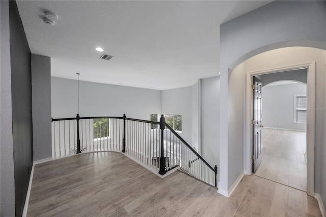 17809 Sandpine Trace Way, Tampa, FL 33647 - hallway with wood finished floors, an upstairs landing, baseboards, arched walkways, and recessed lighting