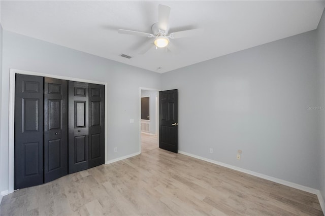 17809 Sandpine Trace Way, Tampa, FL 33647 - unfurnished bedroom with light wood-style flooring, baseboards, ceiling fan, and a closet