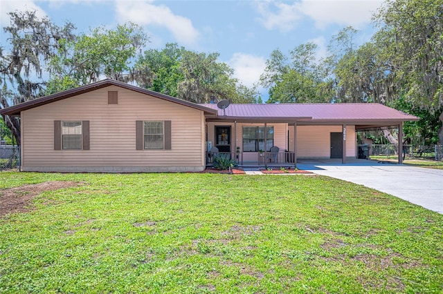 ranch-style house with a carport, driveway, metal roof, and covered porch