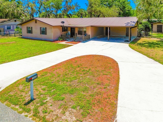 ranch-style home with concrete driveway, covered porch, a carport, and metal roof