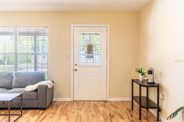 entryway with light wood-style flooring and baseboards