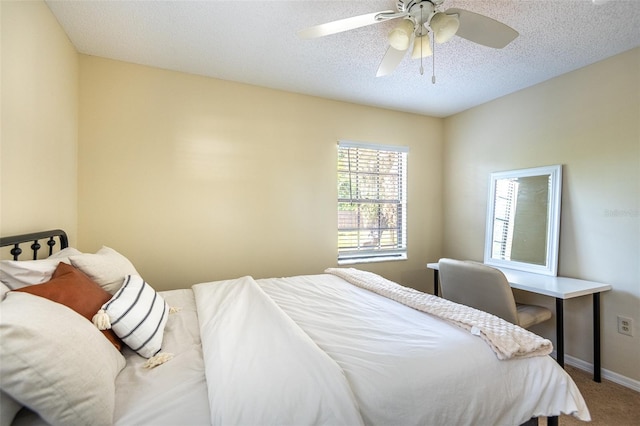 carpeted bedroom with a textured ceiling, ceiling fan, and baseboards