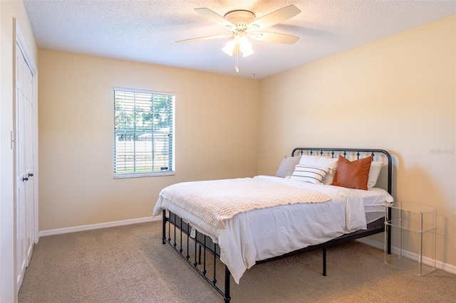 bedroom with carpet floors, baseboards, ceiling fan, and a textured ceiling