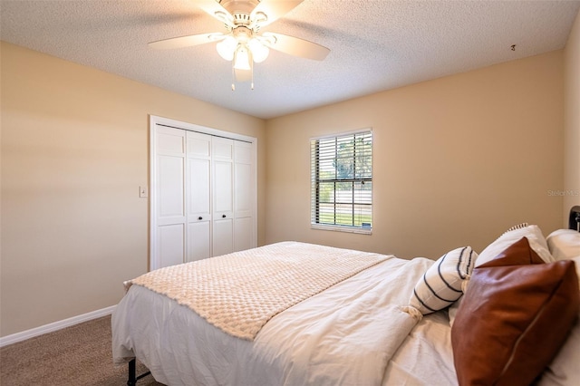 carpeted bedroom with a closet, baseboards, ceiling fan, and a textured ceiling