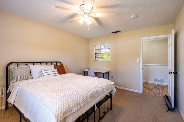 carpeted bedroom with baseboards, a textured ceiling, and a ceiling fan