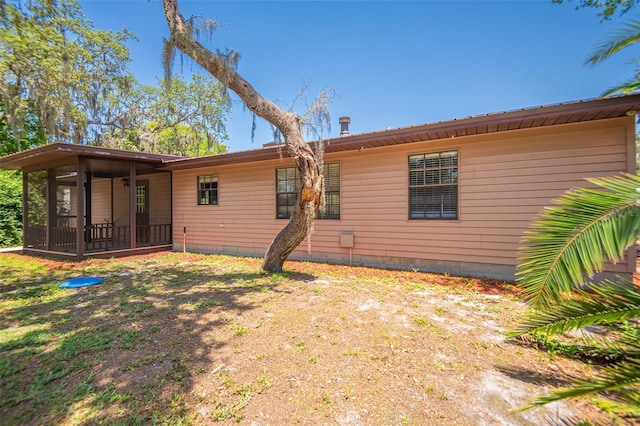 rear view of property featuring a sunroom