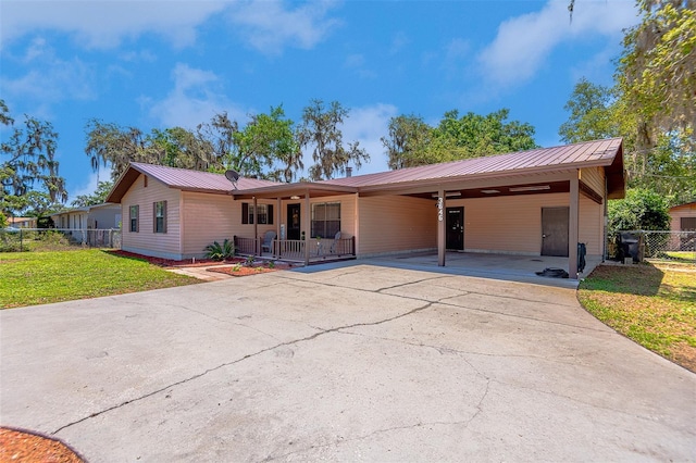 single story home with metal roof, concrete driveway, and an attached carport