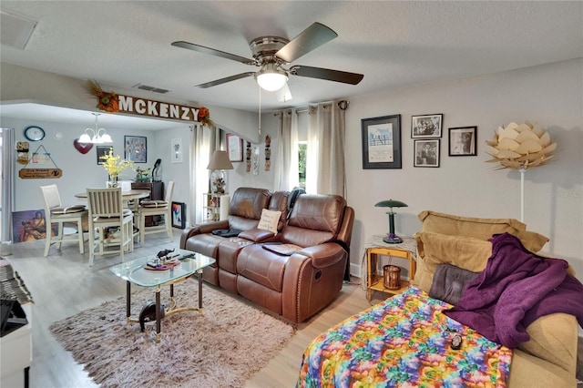 528 S Seminole Ave, Fort Meade, FL 33841 - living area with light wood finished floors, a ceiling fan, a chandelier, and a textured ceiling