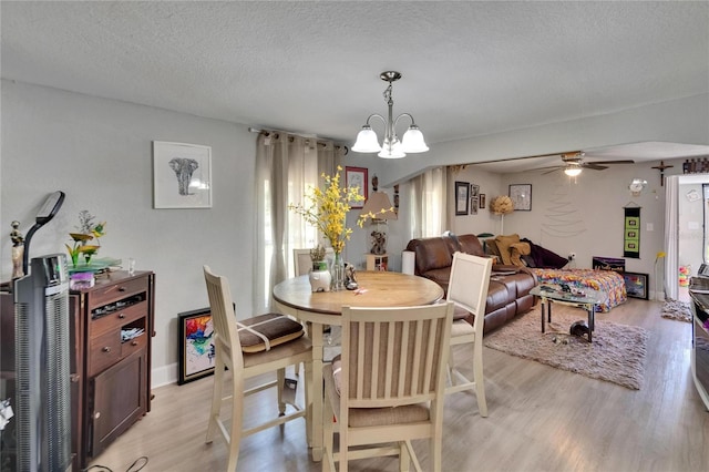 528 S Seminole Ave, Fort Meade, FL 33841 - dining area with light wood-style flooring, a chandelier, a ceiling fan, and a textured ceiling