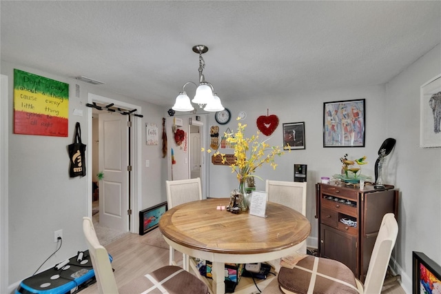 528 S Seminole Ave, Fort Meade, FL 33841 - dining space with light wood-style floors and a chandelier