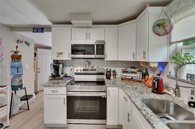 528 S Seminole Ave, Fort Meade, FL 33841 - kitchen with stainless steel appliances, a sink, white cabinets, and tasteful backsplash