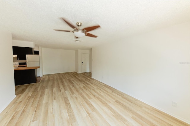 unfurnished living room with a ceiling fan, light wood finished floors, a textured ceiling, and baseboards