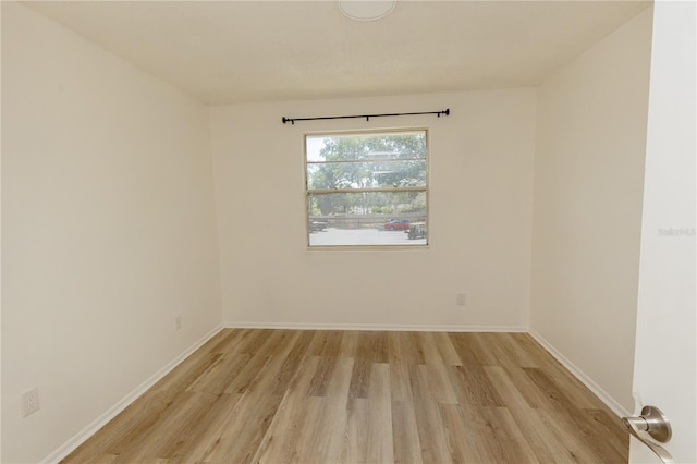 empty room with light wood-style flooring and baseboards
