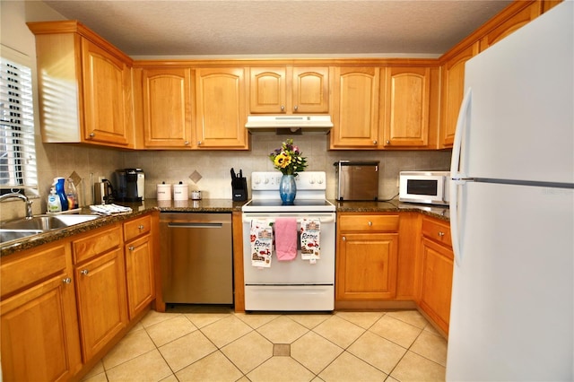6150 Gulfport Blvd S Unit 302, Gulfport, FL 33707 - kitchen featuring white appliances, under cabinet range hood, a sink, decorative backsplash, and light tile patterned floors