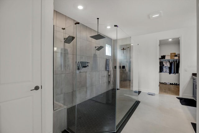 full bath with a shower stall, baseboards, a spacious closet, recessed lighting, and tile patterned floors