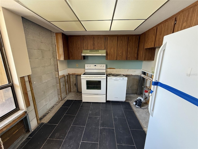 2621 Cove Cay Dr Unit 206, Clearwater, FL 33760 - kitchen with white appliances, under cabinet range hood, light countertops, brown cabinetry, and a drop ceiling