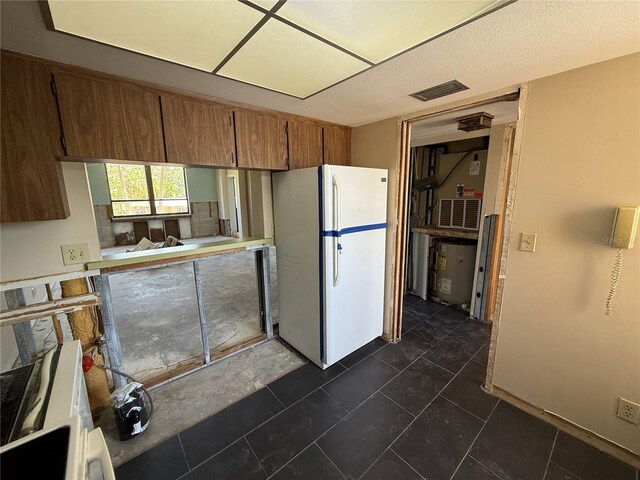 2621 Cove Cay Dr Unit 206, Clearwater, FL 33760 - kitchen with freestanding refrigerator and brown cabinets