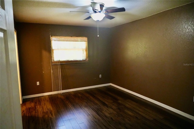empty room featuring dark wood-style flooring, ceiling fan, and baseboards