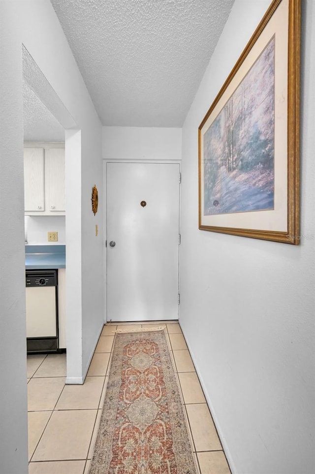 8 Glencoe Pl Unit 305, Dunedin, FL 34698 - hall with light tile patterned floors, a textured ceiling, and baseboards