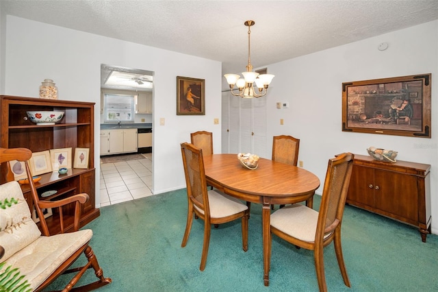 8 Glencoe Pl Unit 305, Dunedin, FL 34698 - carpeted dining space with a chandelier, a sink, and a textured ceiling