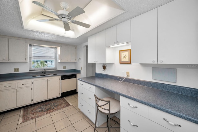 8 Glencoe Pl Unit 305, Dunedin, FL 34698 - kitchen featuring dishwasher, a sink, light tile patterned floors, dark countertops, and a textured ceiling