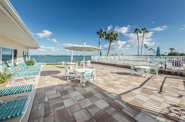 8 Glencoe Pl Unit 305, Dunedin, FL 34698 - view of patio / terrace with a water view, outdoor dining area, fence, and a pool