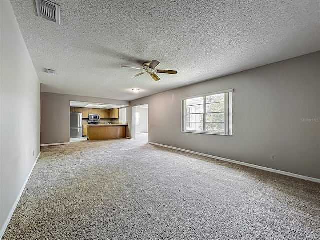 unfurnished living room featuring ceiling fan, light colored carpet, baseboards, and a textured ceiling